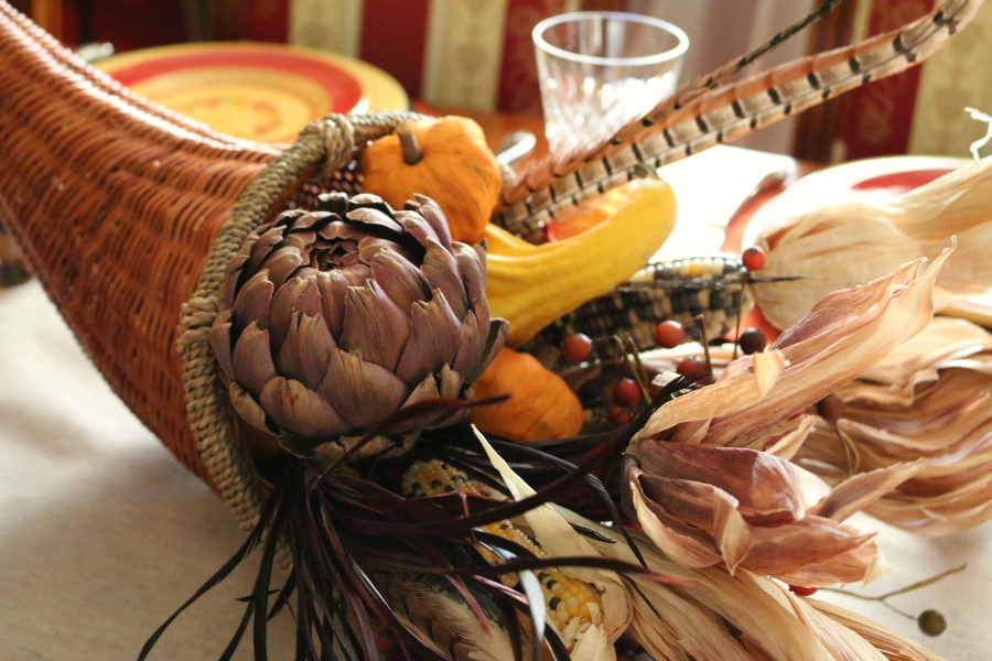 The centerpiece was filled with corn, feathers, pumpkins, dried purple artichoke, and squash.